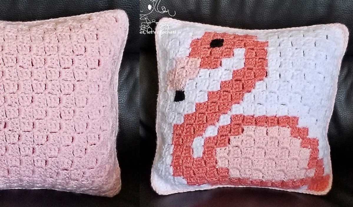 Two crocheted pillows: one with a plain pink pattern, the other featuring a pink flamingo on a white background, crafted from a free crochet pattern. Both pillows are placed on a dark sofa.