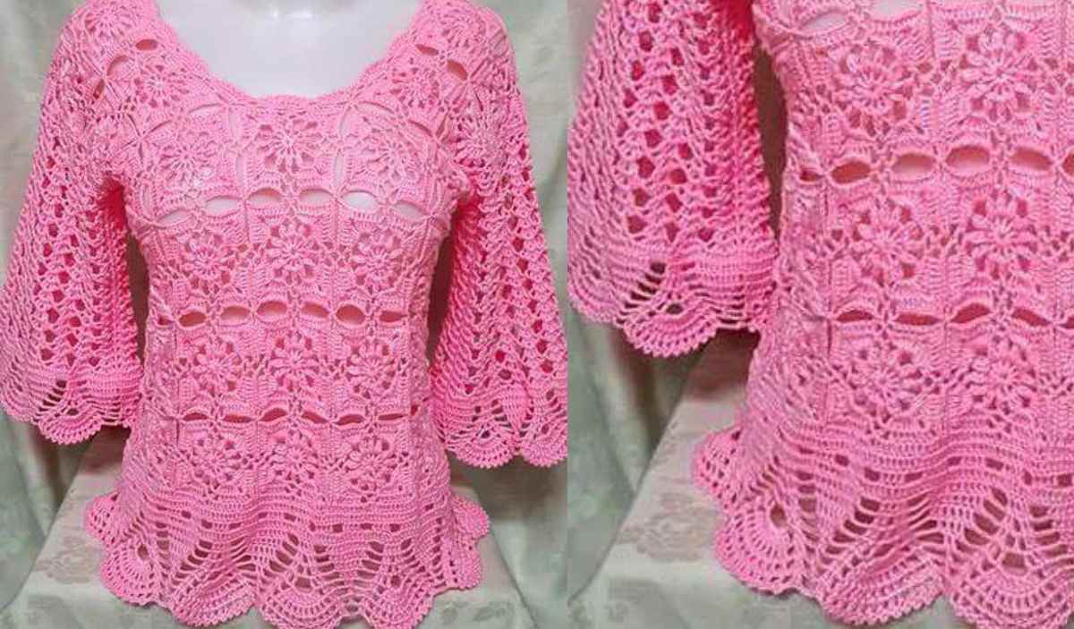 On a mannequin, a pink crochet blouse showcases its scalloped hem and detailed floral patterns. This openwork blouse features three-quarter sleeves and a scoop neckline, offering an elegant touch.