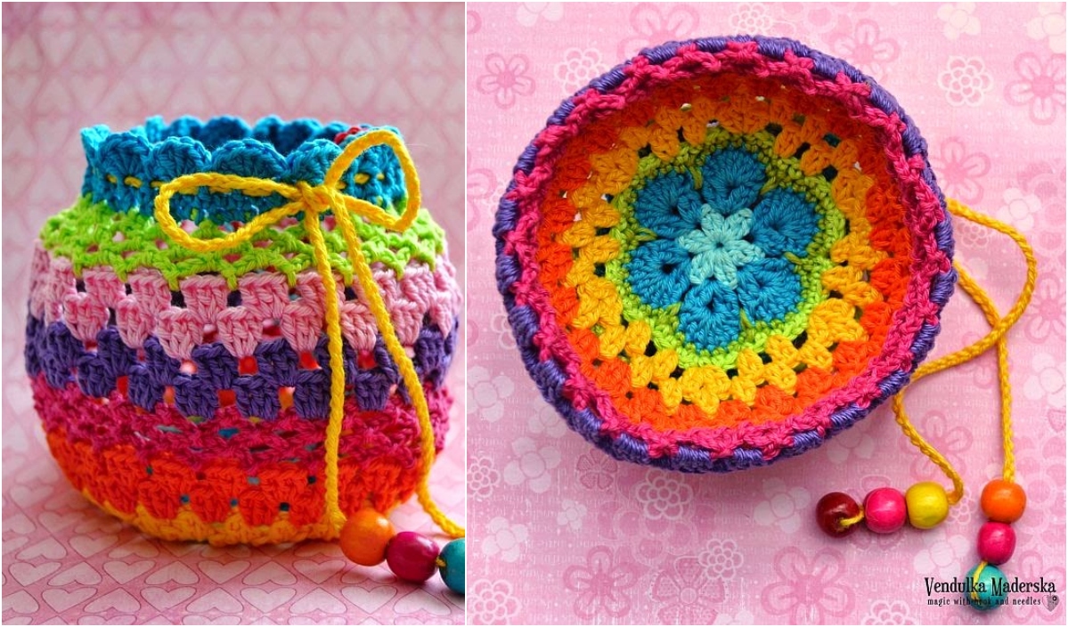 This girls' drawstring purse is a vibrant crocheted pouch featuring a round base. Its rainbow pattern and yellow drawstring adorned with beads perfectly complement the pink background with subtle heart designs.
